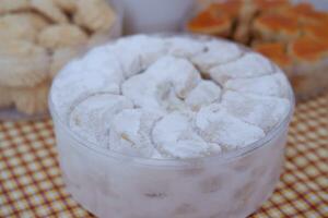 Coconut cookies in a glass bowl on checkered tablecloth photo