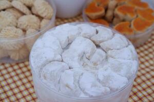 Coconut cookies in a glass bowl on checkered tablecloth photo