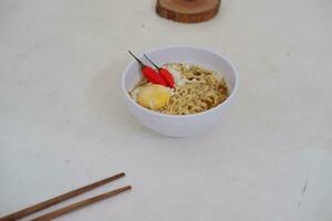 Noodles in a bowl on a white background with chopsticks photo