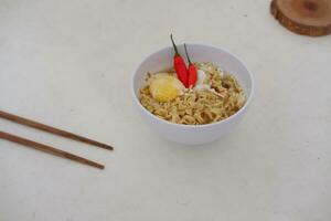 Noodles in a bowl on a white background with chopsticks photo