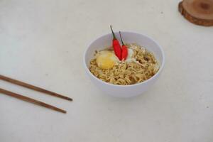 Noodles in a bowl on a white background with chopsticks photo