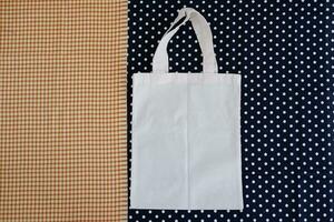 White cotton bag on a blue and white polka dot background. photo