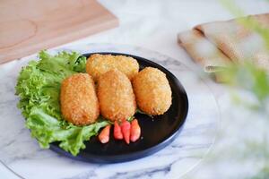 Fried croquettes on a black plate. Selective focus. photo