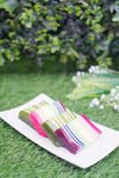 Kue Lapis or or Rainbow sticky layer cake, Indonesian traditional dessert made from rice flour and coconut milk, steamed layer by layer. Selective focus. photo