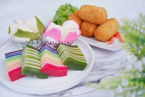 frito croquetas, esponja magdalena y arco iris pegajoso capa pastel indonesio tradicional postre foto