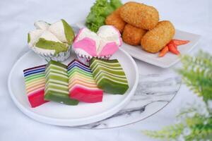 frito croquetas, esponja magdalena y arco iris pegajoso capa pastel indonesio tradicional postre foto