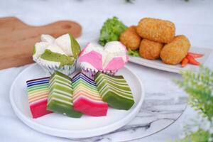 frito croquetas, esponja magdalena y arco iris pegajoso capa pastel indonesio tradicional postre foto