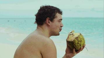 man på de strand dricka från kokos video