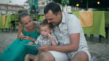 familie van drie Aan toevlucht met tablet pc video