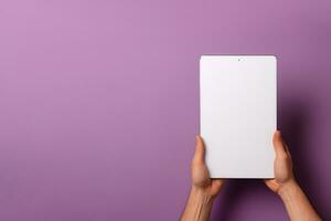 Hand holding tablet with mockup blank screen isolated on purple background with copy space. ai generated photo