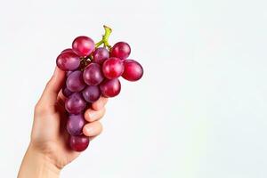 Hand holding a bunch of red grapes isolated on a white background with copy space. ai generated photo