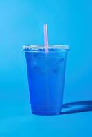 Blue drink in a plastic cup isolated on a blue background. Take away drinks concept. ai generated photo