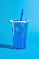 Blue drink in a plastic cup isolated on a blue background. Take away drinks concept. ai generated photo