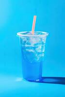 Blue drink in a plastic cup isolated on a blue background. Take away drinks concept. ai generated photo