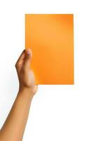 A human hand holding a blank sheet of orange paper or card isolated on a white background. ai generated photo