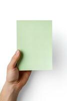 A human hand holding a blank sheet of green paper or card isolated on a white background. ai generated photo