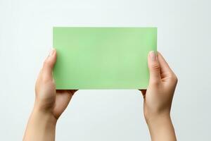 A human hand holding a blank sheet of green paper or card isolated on a white background. ai generated photo