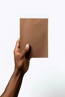 A human hand holding a blank sheet of brown paper or card isolated on a white background. ai generated photo