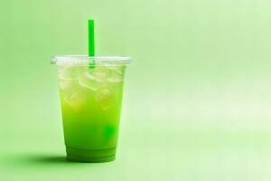 verde bebida en un el plastico taza aislado en un verde antecedentes. tomar lejos bebidas concepto con Copiar espacio. ai generado foto