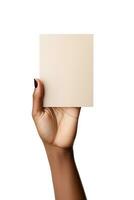 A human hand holding a blank sheet of beige paper or card isolated on a white background. ai generated photo