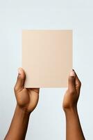 A human hand holding a blank sheet of beige paper or card isolated on a white background. ai generated photo