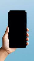 Hand holding smartphone with a black blank screen isolated on a blue background. ai generated photo