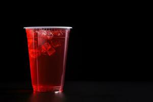 rojo bebida en un el plastico taza aislado en un negro antecedentes. tomar lejos bebidas concepto con Copiar espacio. ai generado foto