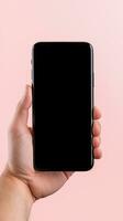 Hand holding smartphone with a black blank screen isolated on a pink background. ai generated photo