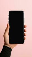 Hand holding smartphone with a black blank screen isolated on a pink background. ai generated photo