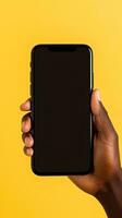 Hand holding smartphone with a black blank screen isolated on a yellow background. ai generated photo