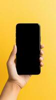 Hand holding smartphone with a black blank screen isolated on a yellow background. ai generated photo