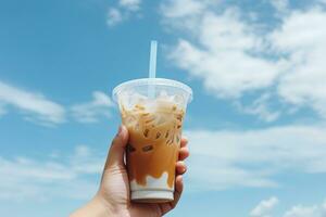 mano participación con hielo café en un el plastico taza con un azul cielo y nube antecedentes. ai generado foto