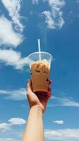 mano participación con hielo café en un el plastico taza con un azul cielo y nube antecedentes. ai generado foto