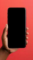 Hand holding smartphone with a black blank screen isolated on a red background. ai generated photo