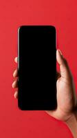 Hand holding smartphone with a black blank screen isolated on a red background. ai generated photo