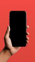 Hand holding smartphone with a black blank screen isolated on a red background. ai generated photo