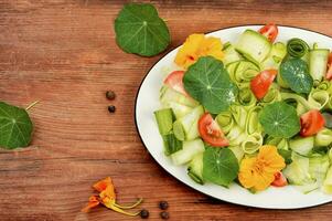 Fresco hierba ensalada con capuchina flores foto