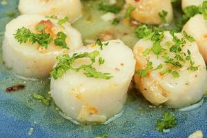 Grilled scallop with butter sauce, closeup. photo