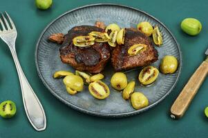 Grilled ostrich steak with kiwi berries photo