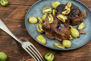 Fried ostrich steak with kiwi sauce photo