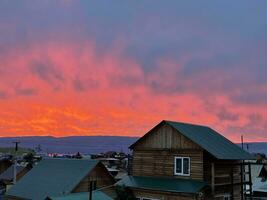un extraordinariamente brillante, ardiente rojo puesta de sol terminado el pueblo de kuzhir, olkhon, Baikal, Rusia foto