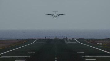 Airplane coming in for landing on runway overlooking ocean video