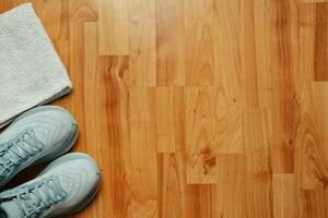 New female running shoes and towel on wooden floor photo