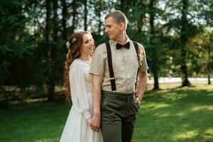 Boda caminar de el novia y novio en un conífero foto