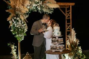 newlyweds happily cut and taste the wedding cake photo