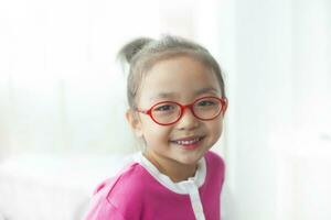 An Asian girl wearing glasses is smiling happily. photo