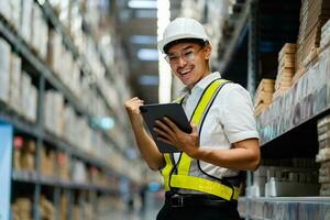 logística industria concepto exitoso. asiático masculino almacén trabajador vistiendo un la seguridad chaleco trabajando en un depósito. foto