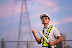 Engineer standing at power station watching power generation planning work at high voltage pole, electrical engineer power station photo