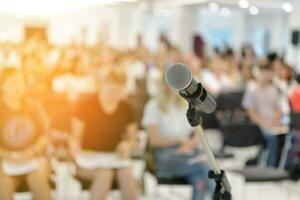 Microphone over abstract blurred of attendee in seminar room photo