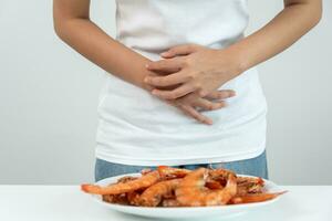 comida alergias, mujer tener reacciones Comezón y enrojecimiento después comiendo camarón, Mariscos alergia, picor, erupción, abdominal dolor, diarrea, cofre opresión, inconsciencia, muerte, grave evitar alergias foto